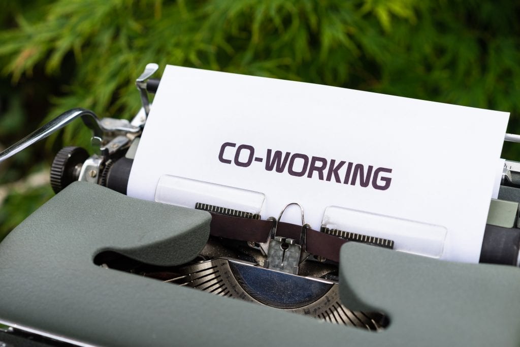 Image of a typewriter with a sheet of paper on the reel stating " co-working". Co-working and outsourcing social media management nable you to build your brand, client base, and market your business effectively and efficiently without stress and commonly encountered teething pains.  
