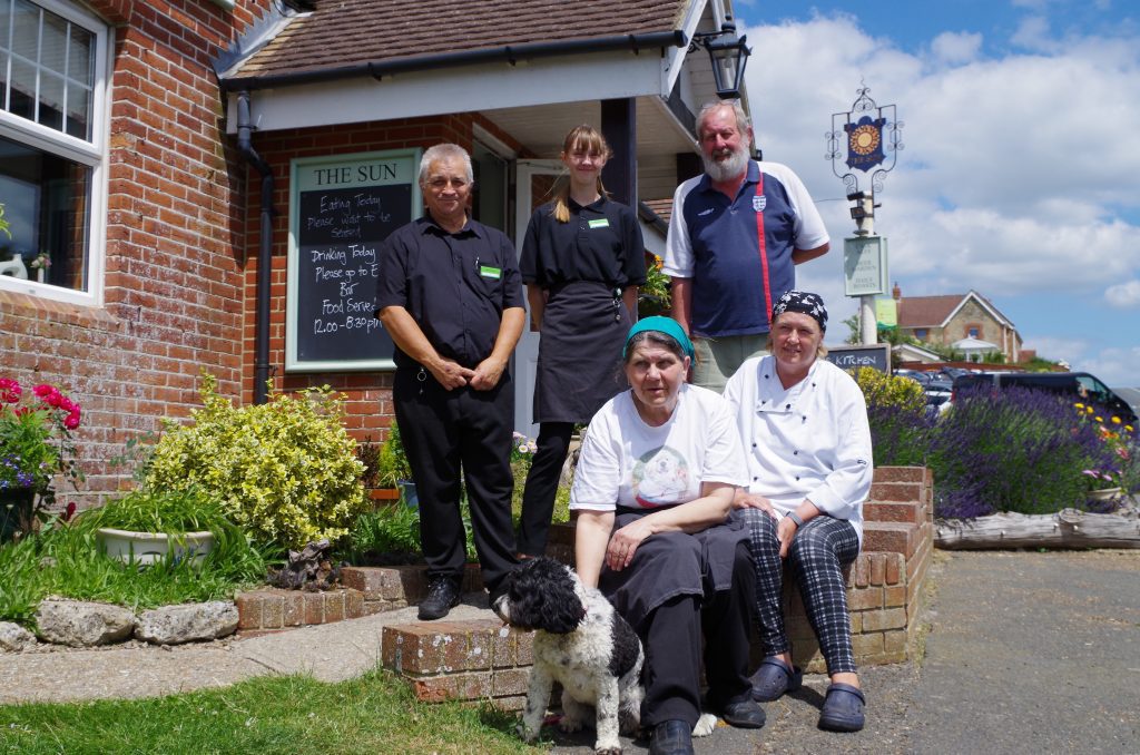 The staff gathered outside of country pub, The Sun Inn, Calbourne. Showing the waiting and kitchen staff.